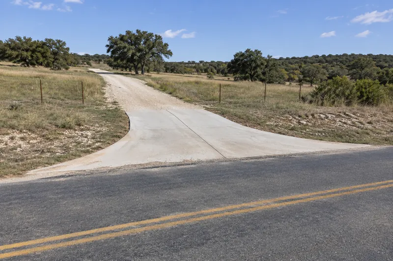 Concrete Contractor in China Spring, TX, example photo: concrete approach joining a gravel ranch driveway to a two-lane country road