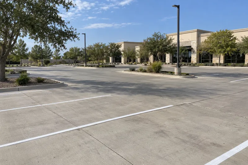 Concrete Contractor in Lacy-Lakeview, TX, example photo: a shopping-centre concrete parking lot with fresh striping and light poles