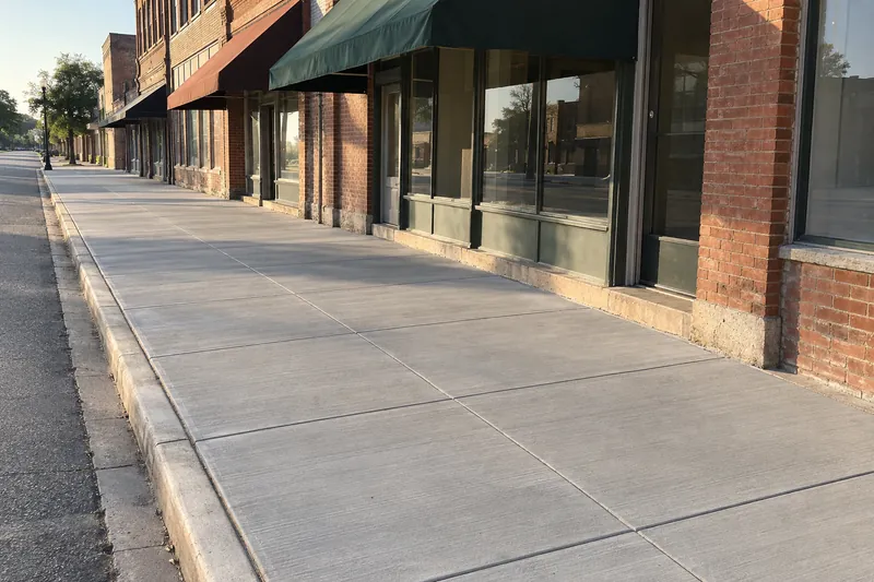 Concrete Contractor in Marlin, TX, example photo: new concrete sidewalk along older brick buildings on a small-town street