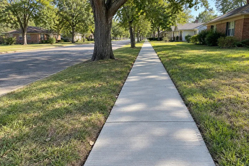 Concrete Contractor in West, TX, example photo: new sidewalk with tooled joints along a street of older houses