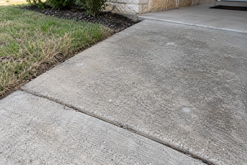 Concrete Leveling in West, TX, example photo: small drilled injection holes, patched, in a lifted slab