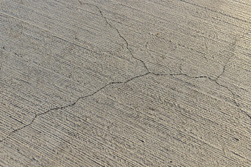 Concrete Repair in Mart, TX, example photo: hairline shrinkage cracks across a broom-finished slab
