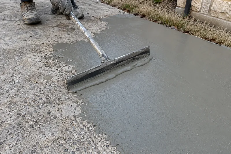 Concrete Resurfacing in Bruceville-Eddy, TX, example photo: cement resurfacer being spread over worn concrete with a squeegee